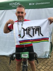 cyclist with medal holding up the more then metal flag